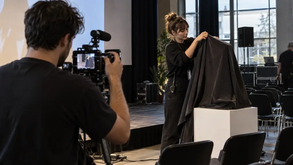 Illustration IA : Équipe préparant la révélation d’un produit pour le tournage d’un teaser vidéo.